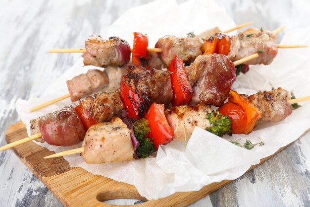 Brocheta de cerdo en la mesa de madera de cerca