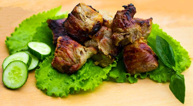 Brocheta de cerdo en una mesa de madera.