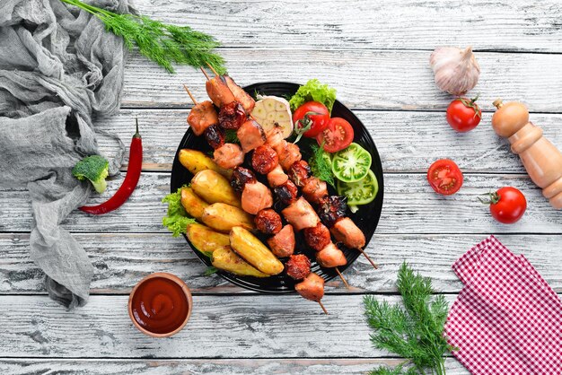 Brocheta de pollo con patatas y verduras sobre un fondo blanco de madera Carne Vista superior Espacio de copia libre