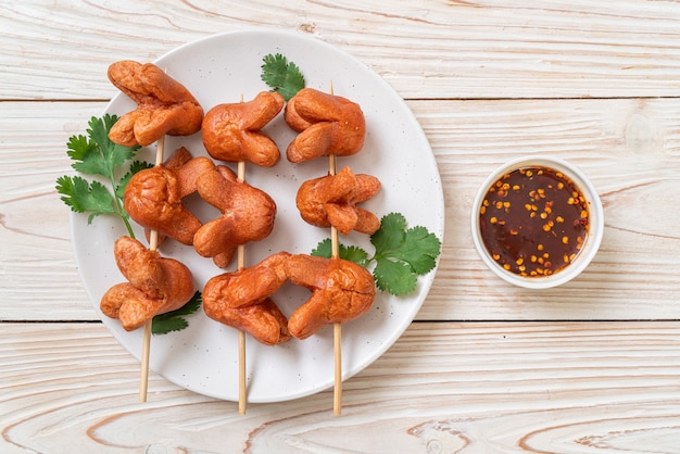 Brocheta de salchicha frita con salsa para mojar