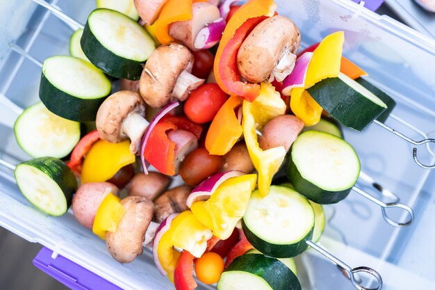 Brocheta de verduras lista para ser asada en una parrilla de gas al aire libre.