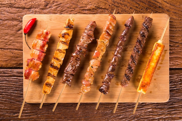 Brochetas de bistec variadas en la parte superior de una tabla