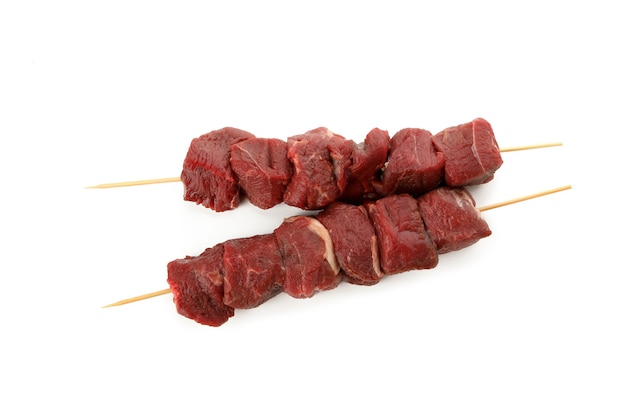 Brochetas con carne cruda aislado en blanco