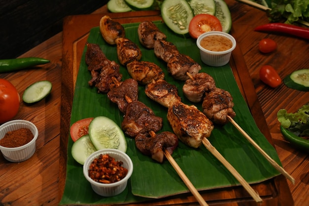 Brochetas de carne a la parrilla calientes, picantes y deliciosas con pimienta de Sichuan y verduras sobre fondo de madera