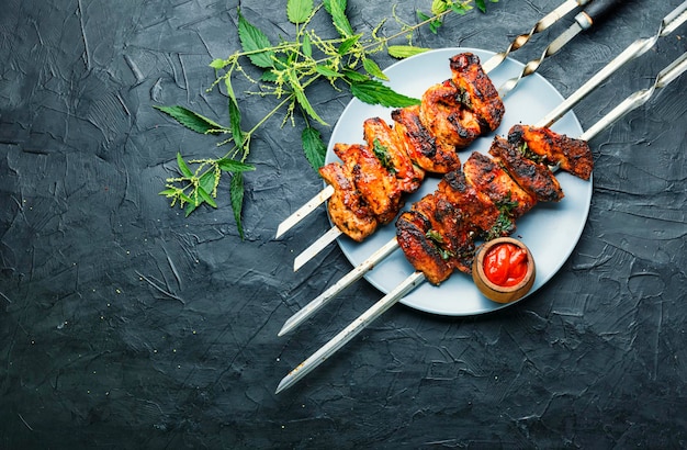 Brochetas de carne a la parrilla o shish kebab en escabeche con follaje de ortiga