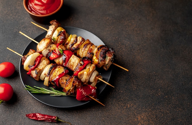 Brochetas de carne con verduras a la parrilla en un plato sobre un fondo de piedra