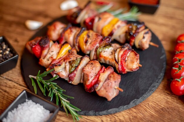 Brochetas de carne con verduras a la parrilla sobre un fondo rústico