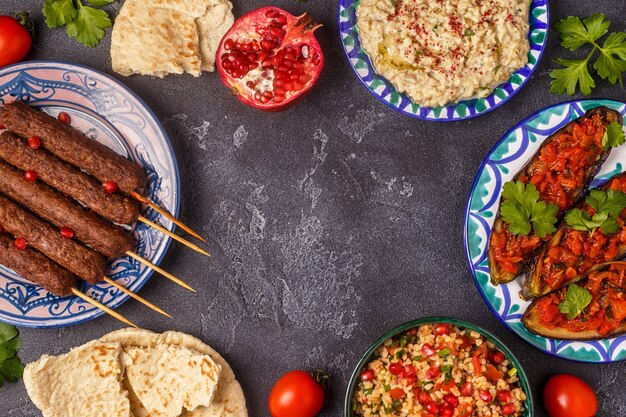 Brochetas clásicas, ensalada tabbouleh, baba ganush y berenjena al horno con salsa.