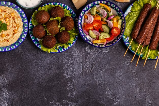 Brochetas clásicas, falafel y hummus en los platos