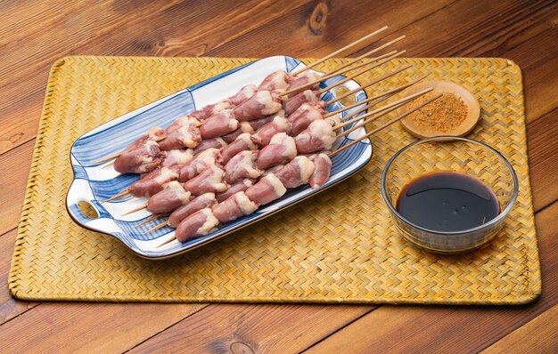 Brochetas de corazón de pollo fresco en un plato de porcelana