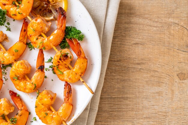 Foto brochetas de gambas tigre a la plancha con limón