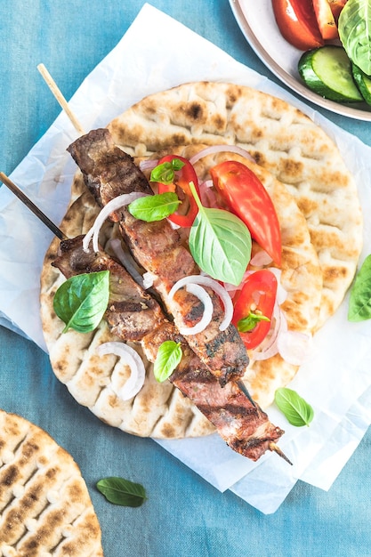 Brochetas de souvlaki de cerdo en brochetas con ensalada y tzatziki recién hecho en casa