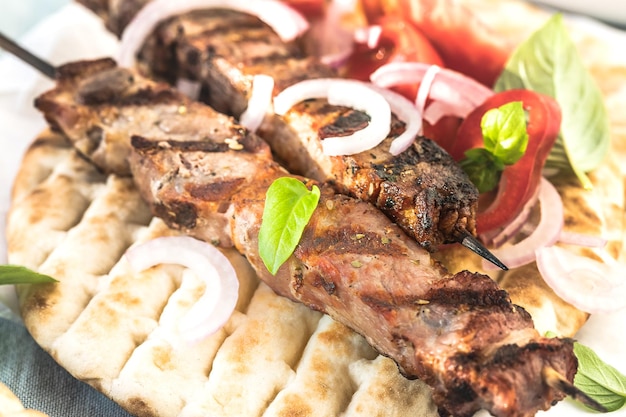 Brochetas de souvlaki de cerdo en brochetas con ensalada y tzatziki recién hecho en casa