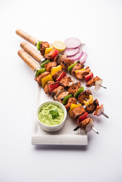 Brochetas tikka de pollo indio, marinado en especias y yogur y asado en tandoor