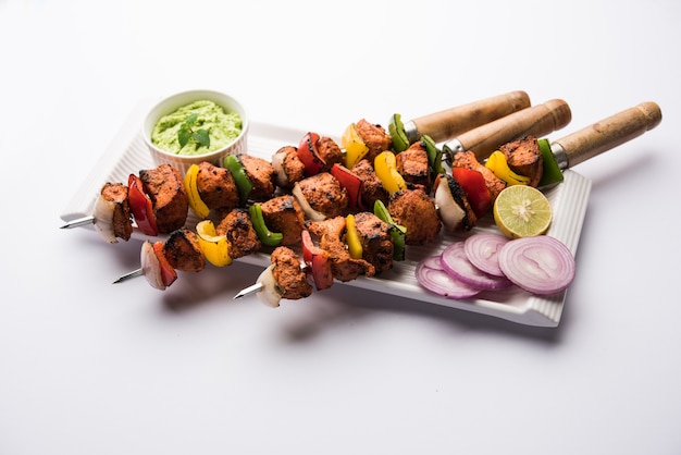 Brochetas tikka de pollo indio, marinado en especias y yogur y asado en tandoor