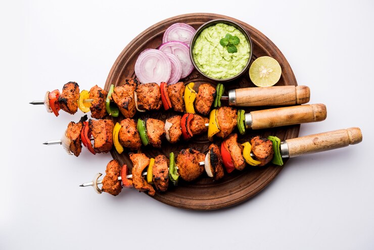 Foto brochetas tikka de pollo indio, marinado en especias y yogur y asado en tandoor