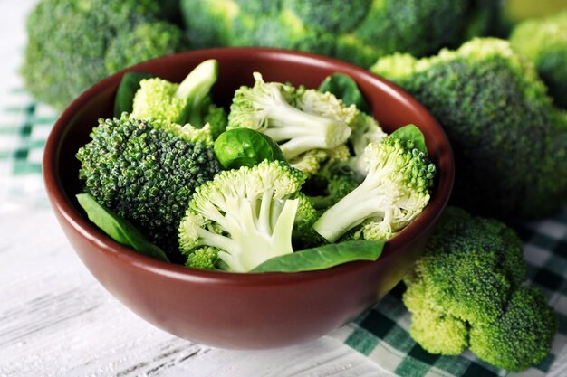 Brócoli fresco con espinacas en un tazón en la mesa de madera de cerca