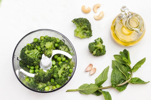 Foto el brócoli de guisantes verdes y las nueces de caju en el cuenco de la licuadora