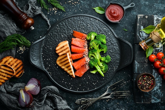 Brócoli y pescado salado de salmón Dieta saludable Comida En un plato de piedra negra Vista superior