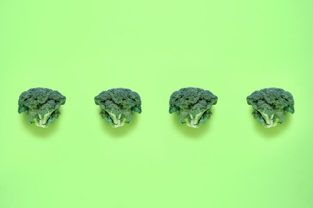 Brócoli sobre un fondo verde Patrón de comida en un estilo minimalista