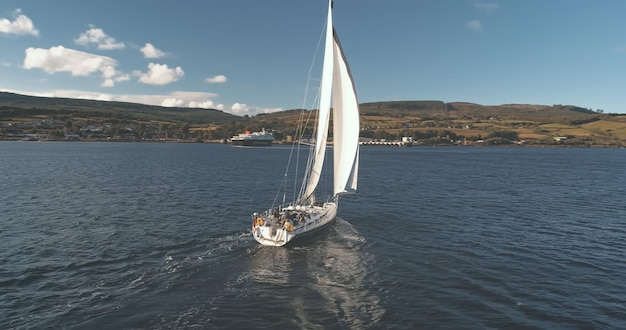 Brodick porto arran ilha Escócia corrida de veleiro em câmera lenta em Ocean Bay cruzeiro aéreo de verão em