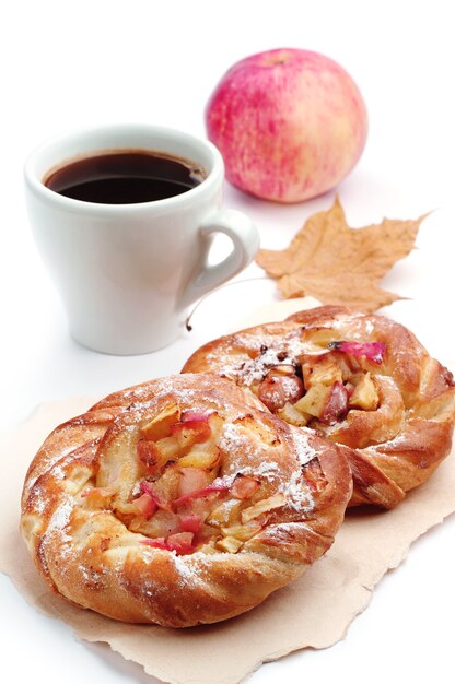 Brötchen mit Apfel und Tasse Kaffee auf weißem Hintergrund