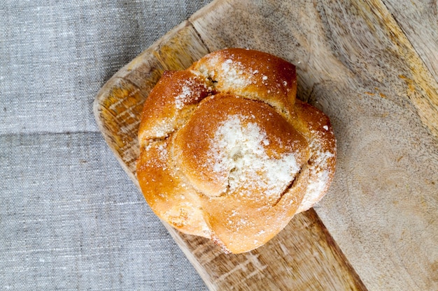 Brötchen mit einem Belag auf einem hölzernen Schneidebrett