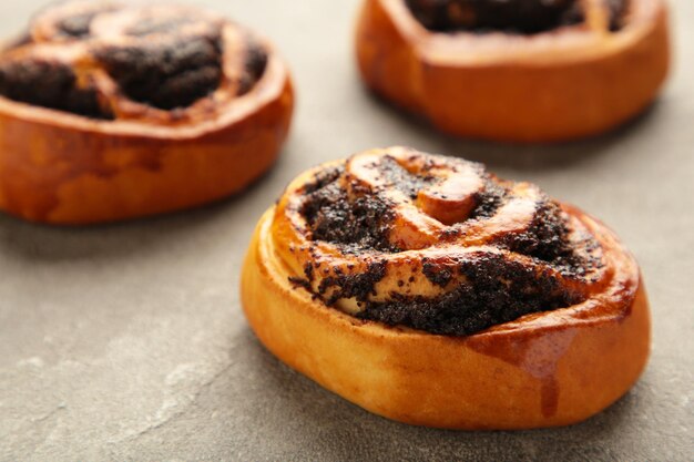 Brötchen mit Mohn auf grauem Hintergrund.