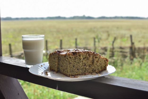 Brötchen mit Mohn mit einem Glas Milch. Milch in einem Glas und Mohnkuchen auf einem Feld