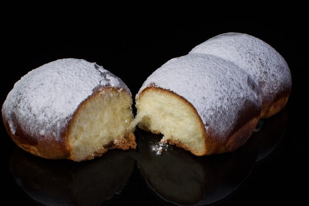 Brötchen mit Puderzucker auf dunklem Hintergrund