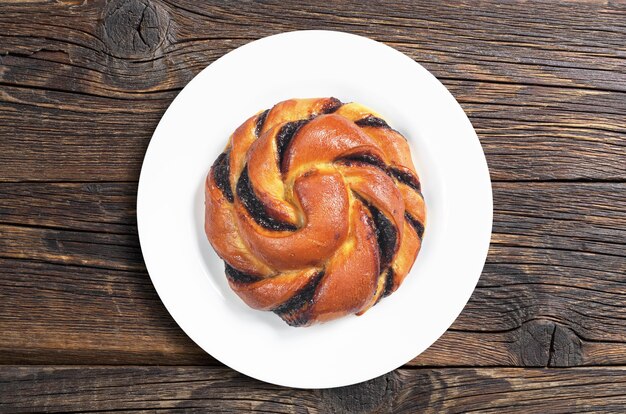 Brötchen mit Schokoladencreme auf einem Teller auf altem hölzernem Hintergrund