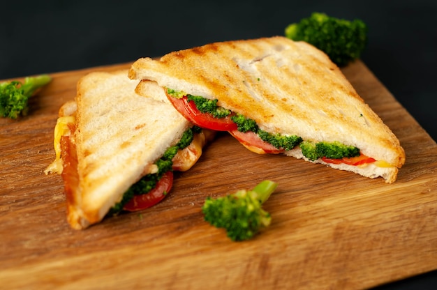 Brokkoli-Käse-Sandwiches auf Holzschneidebrett, auf Beton, Schieferhintergrund