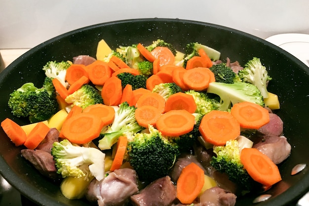 Brokkoli mit Karotten und Fleisch wird in einer Pfanne gekocht