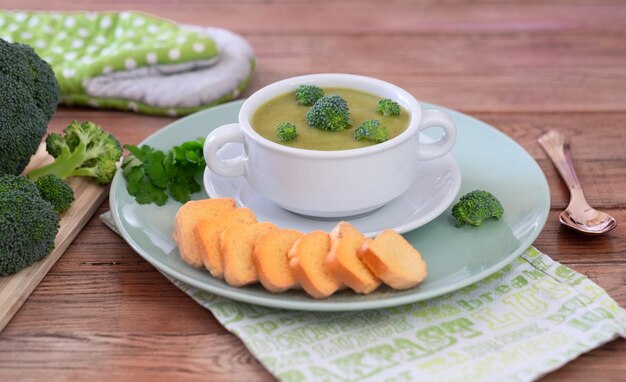 Brokkolicremesuppe mit Croutons für eine gesunde Ernährung ohne Kalorien Holztisch als Hintergrund
