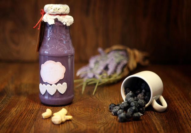 Brombeer-smoothie in der flasche. buntes getränk, milchshake in der flasche mit frischen superfoods auf einem hölzernen hintergrund. gesundes, sauberes essen, veganer, vegetarier, detox, diät-frühstückskonzept