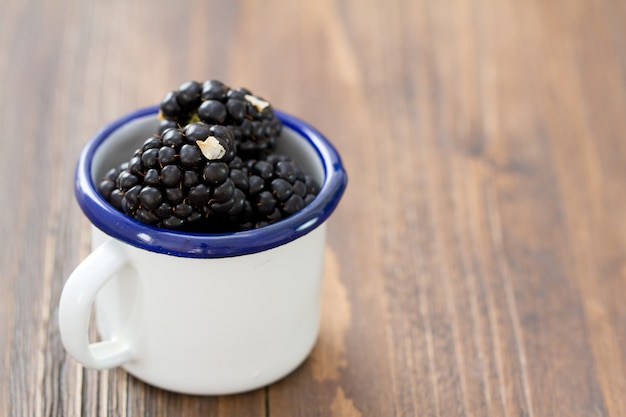 Brombeeren in der weißen Schale auf braunem Holz