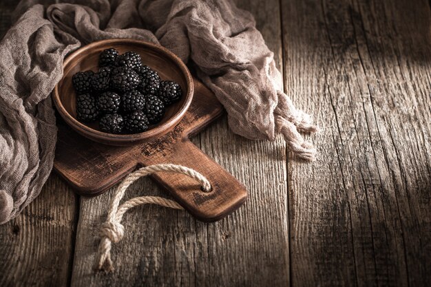 Brombeeren in Platte auf Holzhintergrund.