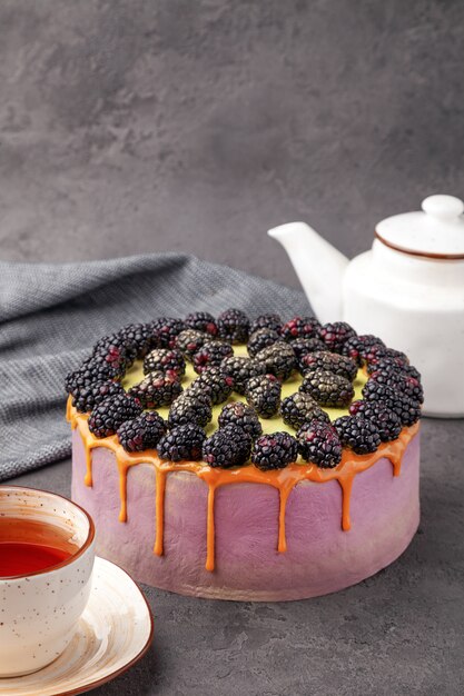 Brombeerkuchen, Teekanne und Teetasse auf grauer Oberfläche