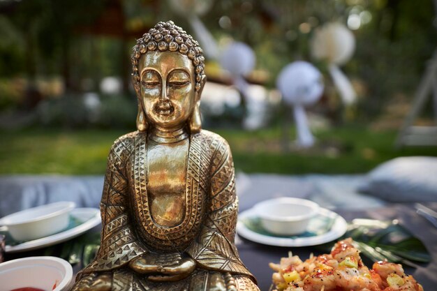 Bronze-Buddha-Figur in der Natur bei einem Picknick Nahaufnahme der Buddha-Figur