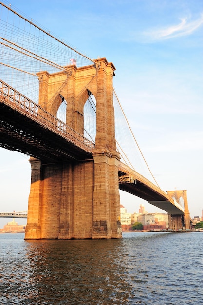 Brooklyn Bridge über den East River gesehen von New York City Lower Manhattan Waterfront bei Sonnenuntergang.