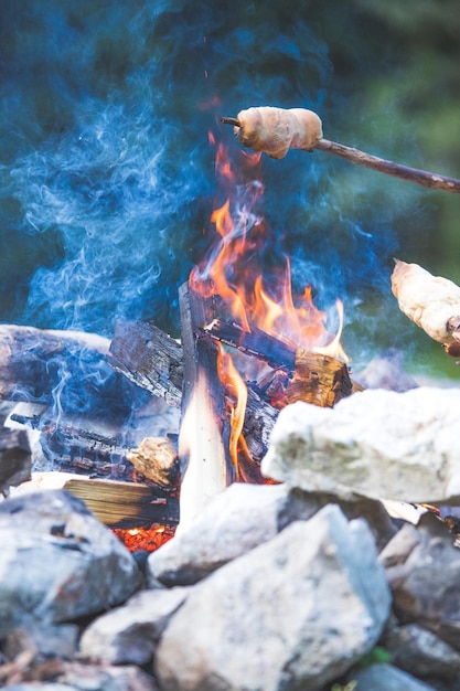 Brot backen über dem Feuer Grillen im Freien mit Lagerfeuer