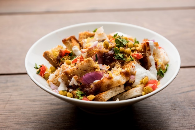 Brot Chaat, Chat ist eine leckere Vorspeise oder Vorspeise aus Indien, serviert in einer Schüssel, garniert mit Tomaten, Sev und Koriander und Masala. selektiver Fokus