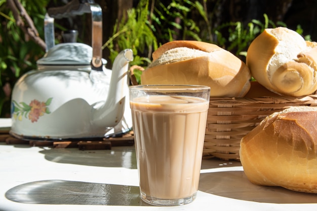 Brot, eine Kanne Kaffee in einer amerikanischen Tasse Milch