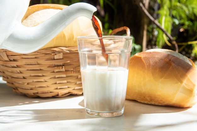 Brot, eine Kanne mit Kaffee in einem amerikanischen Glas Milch