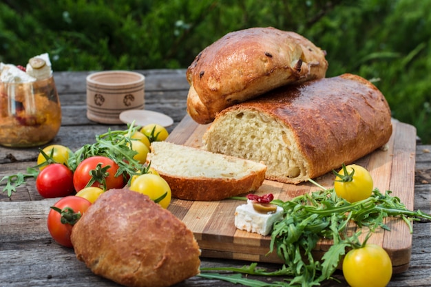 Brot. Gelbe Tomate mit Rucola. Fetakäse mit Oliven und sonnengetrockneten Tomaten. Picknick