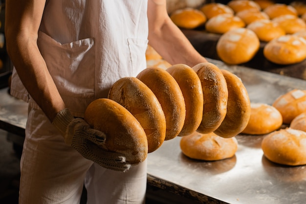 Brot in den Händen eines Bäckers. Industrielle Brotproduktion