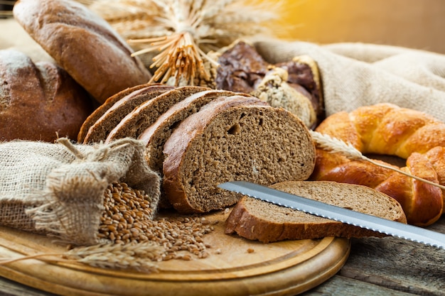 Brot in der Komposition mit Küchenzubehör auf dem Tisch