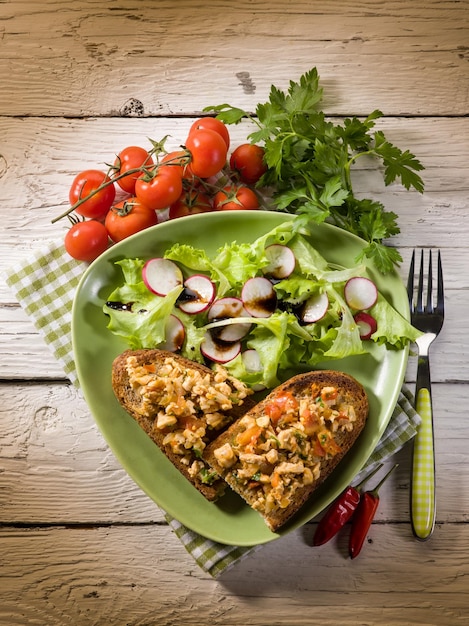 Brot mit Hähnchen und gemischtem Salat in Scheiben schneiden