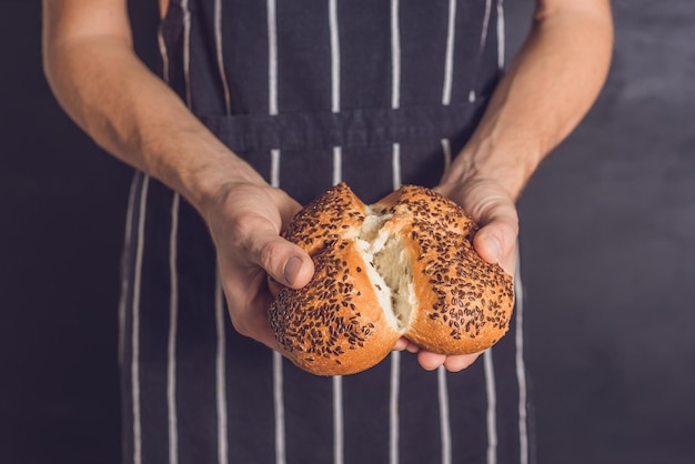 Brot mit Leinsamen in den Händen eines Bäckers