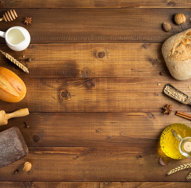 Brot- und Backzutaten auf Holztischhintergrund, Ansicht von oben